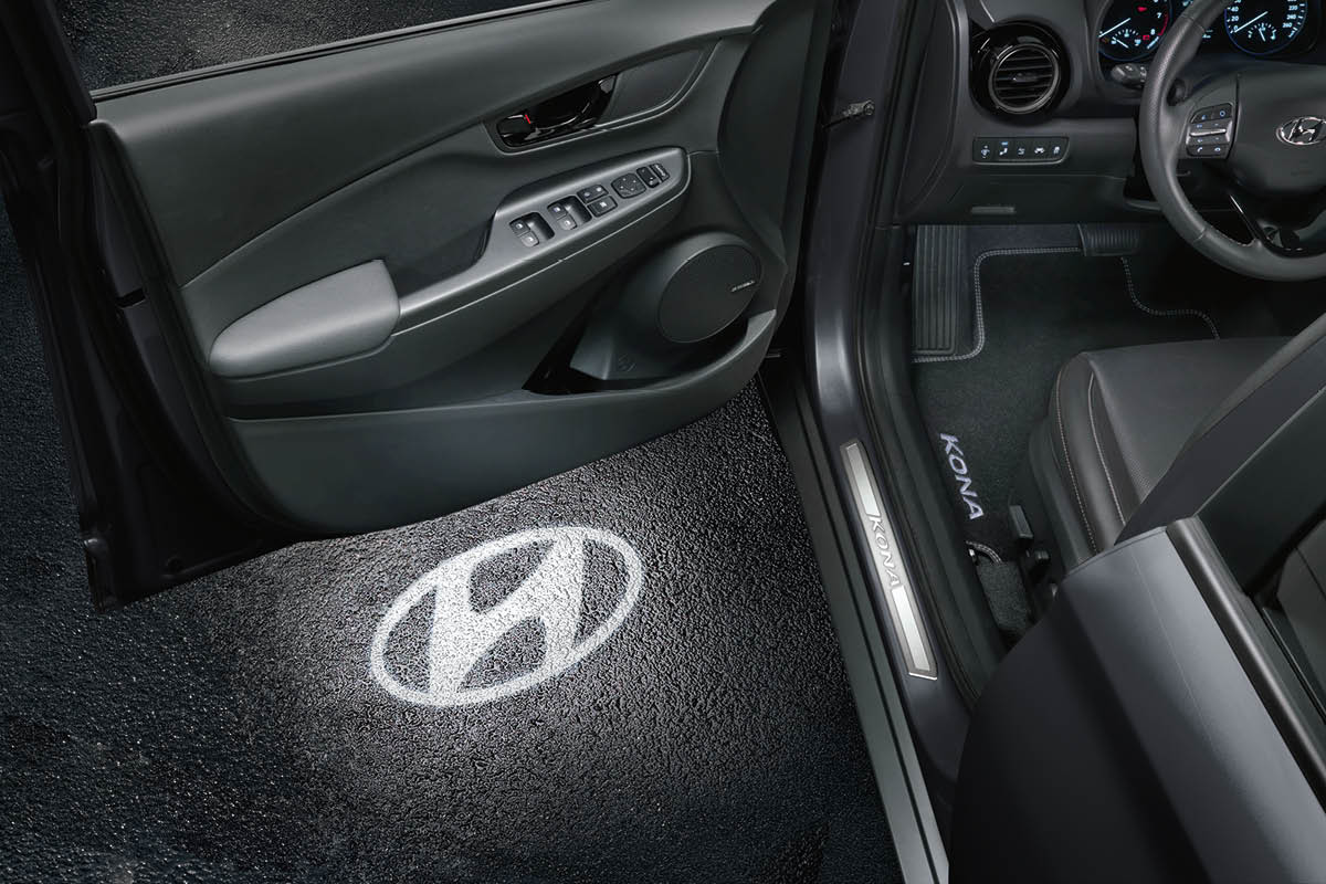 zu sehen ist die geöffnete Tür eines Konas. Auf dem Boden wird das Hyundai Logo abgebildet.