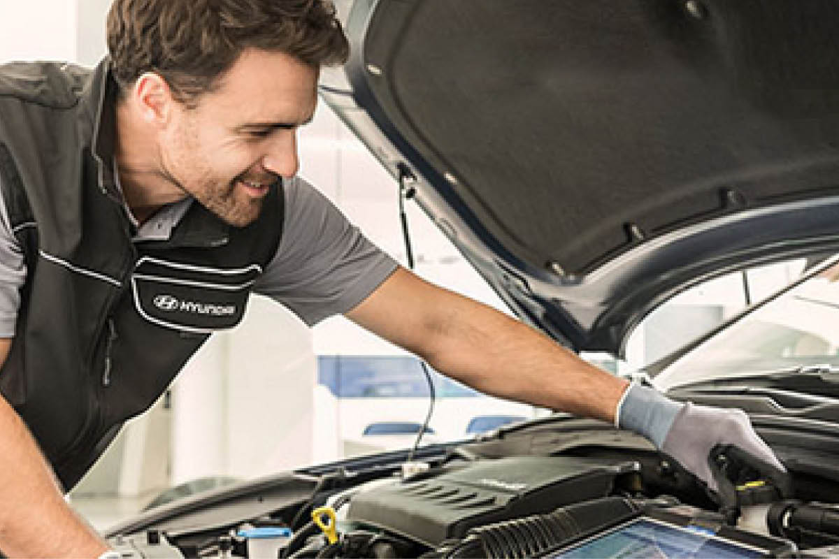 zu sehen ist ein Mitarbeiter, der den Motor prüft