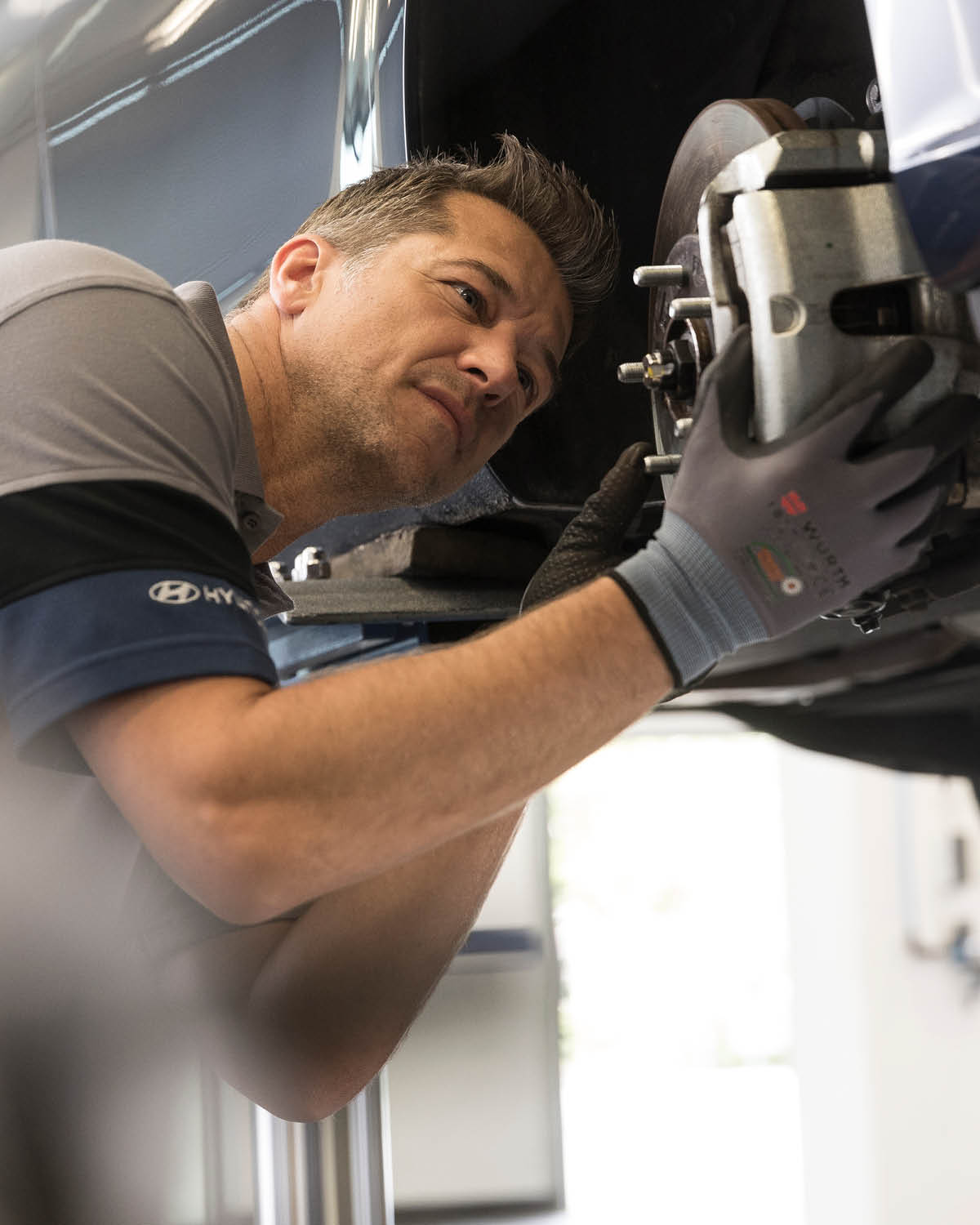 zu sehen ist ein Mitarbeiter, der eine Hyundai Bremse checkt