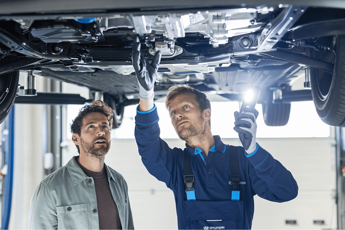 Mechaniker arbeitet am Unterboden eines Hyundai in seiner Werkstatt